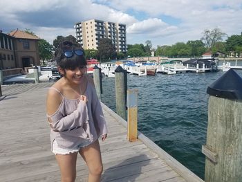 Happy woman standing on boardwalk by lake geneva