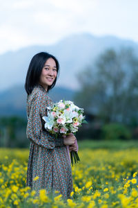 Beautiful young woman standing on field