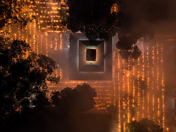 Digital composite image of illuminated trees and buildings at night