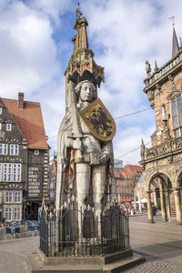 Statue of historic building in city against sky