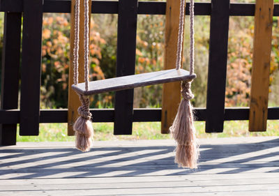 Empty swing hanging on wood