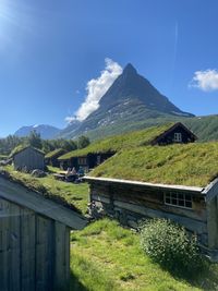 Scenic view of green mountains against blue sky