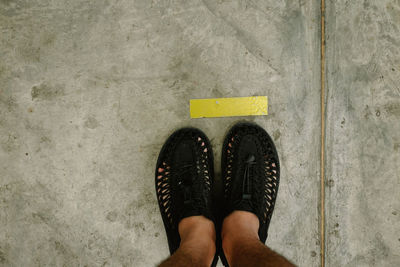 Low section of woman standing on concrete floor