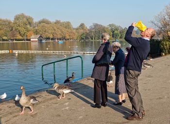 People on lake against clear sky