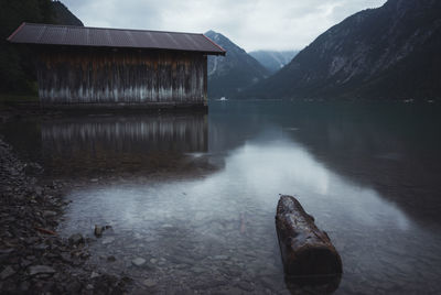 Scenic view of lake by mountains against sky