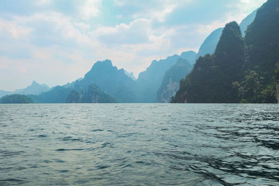 Scenic view of sea and mountains against sky