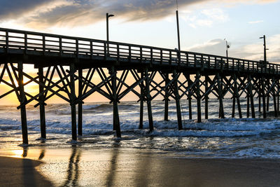 Bridge over calm sea against sky