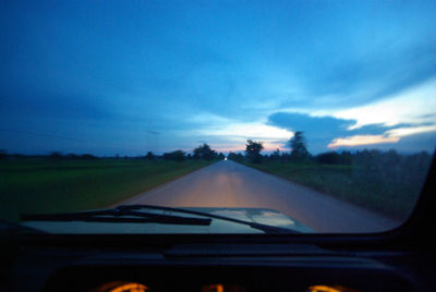 Road seen through car windshield against sky