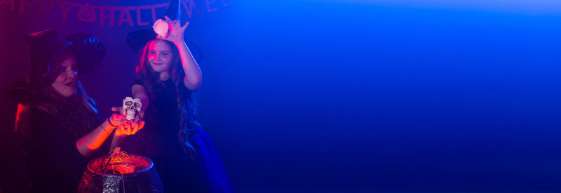 Low angle view of woman using mobile phone against blue background