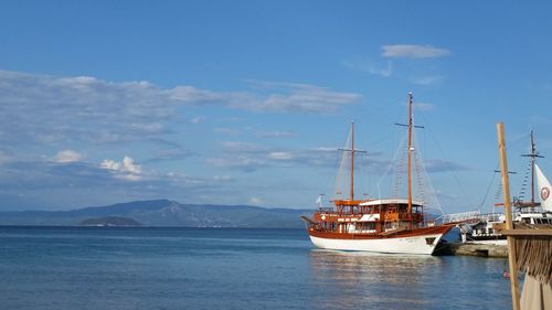 Sailboats moored on sea against sky