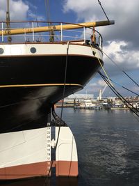 Sailboat moored at harbor against sky