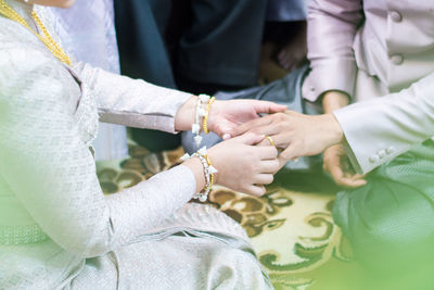 Close-up of woman putting ring on bridegroom