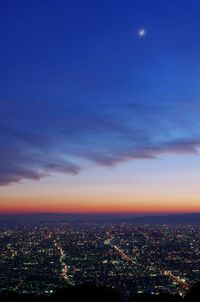 Illuminated cityscape against sky at night