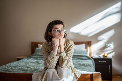 Young woman wearing sunglasses while sitting on table