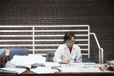 Senior female scientist reading documents at laboratory
