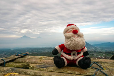Close-up of stuffed toy on mountain against sky