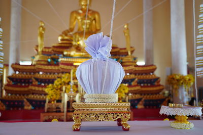 Close-up of illuminated lamp on table in temple