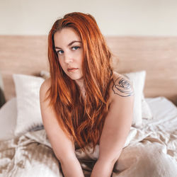 Portrait of beautiful young woman lying in bed