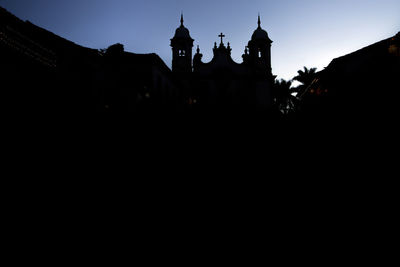 Low angle view of silhouette building against clear sky