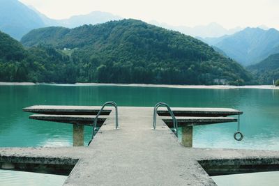 Pier on lake in front of mountains