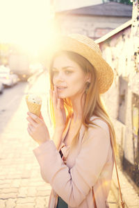 Portrait of smiling young woman holding hat