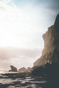 Scenic view of sea by cliff against sky