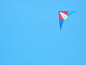 Low angle view of flag against clear blue sky