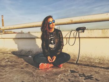 Portrait of young woman against sky