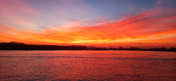 Scenic view of sea against romantic sky at sunset