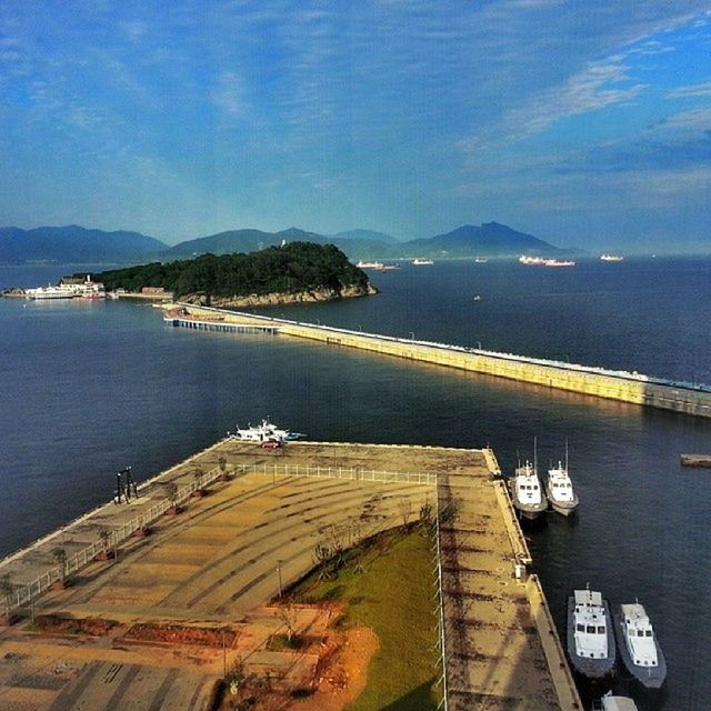 water, sea, mountain, sky, transportation, scenics, tranquil scene, beauty in nature, tranquility, blue, nature, cloud - sky, mountain range, mode of transport, railing, pier, the way forward, high angle view, horizon over water, built structure