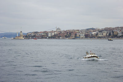 Boats in river with buildings in background