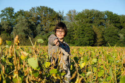 Portrait of woman standing on field against sky