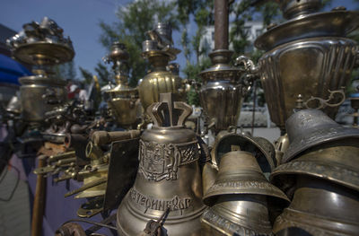 Close-up of antique bells and urns on sunny day