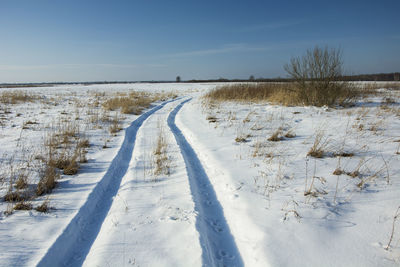 Scenic view of snow covered field against sky