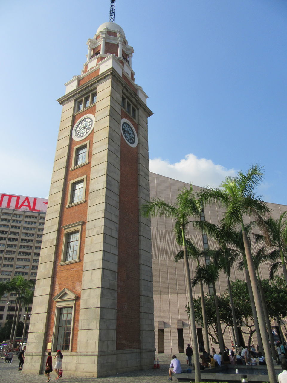 architecture, built structure, building exterior, tower, day, clock, large group of people, clock tower, travel destinations, low angle view, sky, outdoors, palm tree, tree, real people, city, people