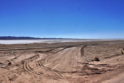 Scenic view of desert against clear blue sky