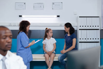 Nurse examining girl in clinic