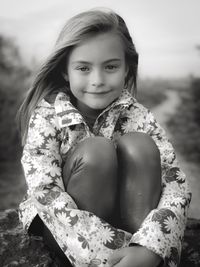 Portrait of smiling girl sitting outdoors