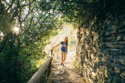 Full length of woman standing on tree trunk