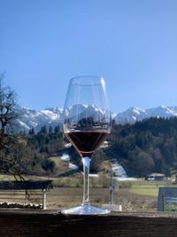 Glass of wine on table against mountain