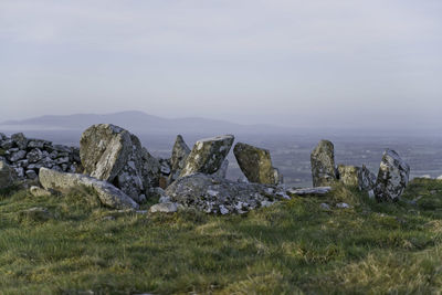 Panoramic view of rocks on field against sky