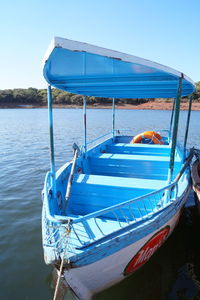 Boats moored in sea against clear blue sky