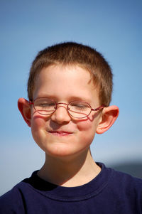 Close-up portrait of smiling boy against sky
