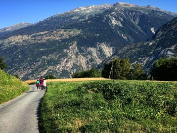 Rear view of people riding motorcycle on road