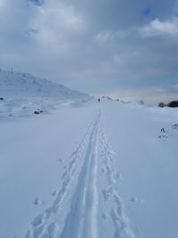 Snow covered landscape against sky