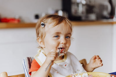 Cute girl eating food at home