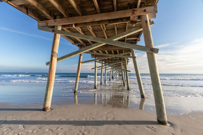 View of pier on beach against sky