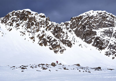 Woman snowshoe hiking in snowy mountains during sunrise in winter