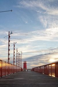 Bridge over street against sky during sunset