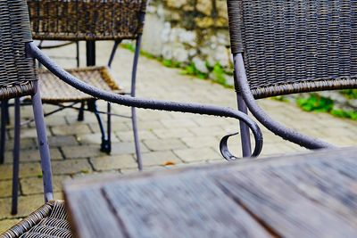 Close-up of empty bench against railing